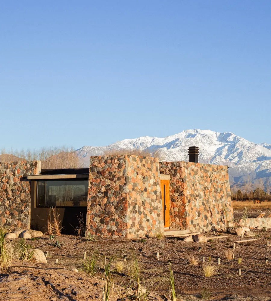 Stone house with fireplace and snowy mountains in the background