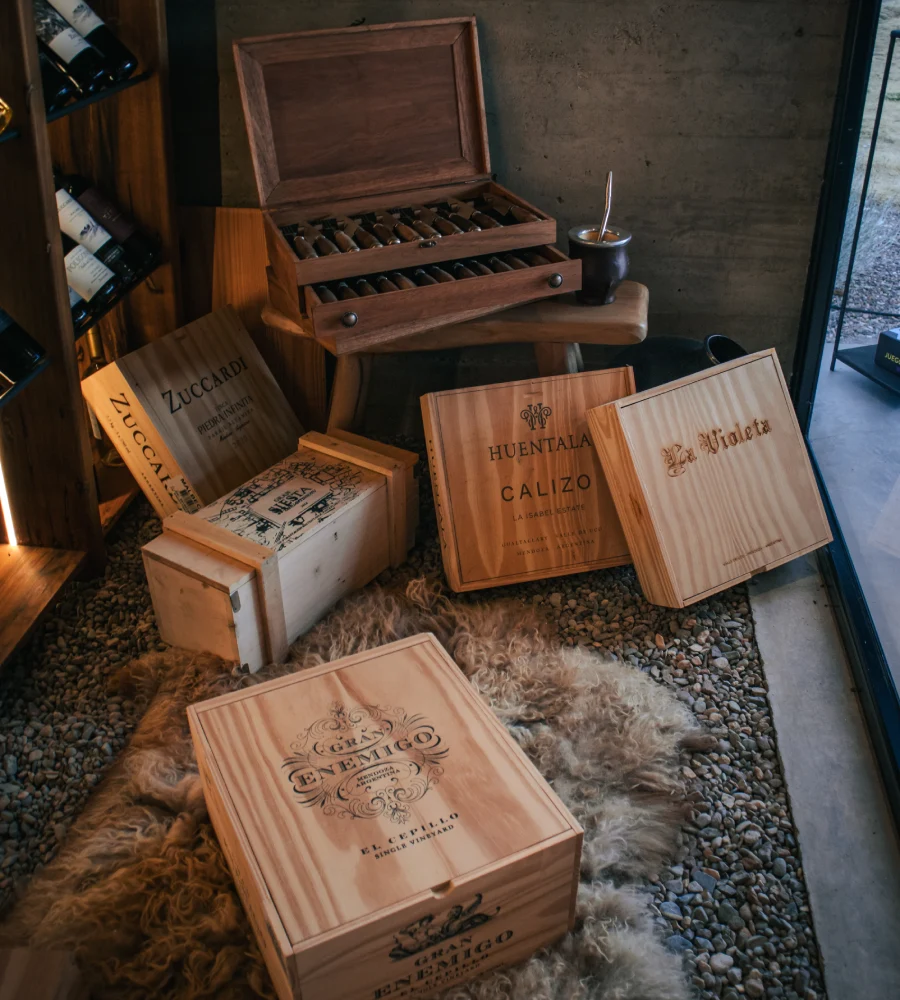 Box of wines and wooden deck with "Zuccardi", "Huental&aacute;", and "Violeta" boxes